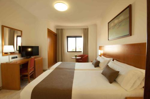 圣克鲁斯-德特内里费和平王子酒店的酒店客房设有一张大床和一张书桌。