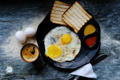 麦罗肯机Mitra Hostel Mcleodganj的早餐盘包括鸡蛋、烤面包和咖啡