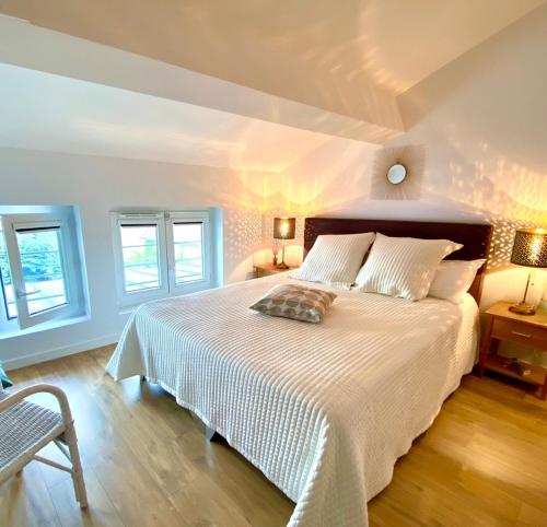 博讷La Dormance的卧室配有白色的床和2扇窗户。