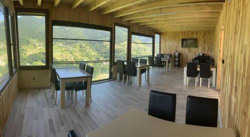 特拉布宗Yamaç Çam Hotel的用餐室配有桌椅和大窗户