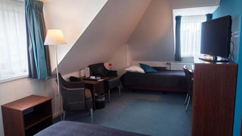 西泰尔斯海灵吾普科斯酒店的小房间设有床铺和电视