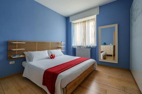 米兰Bike Stop Milan的蓝色的卧室,配有一张大床,上面有红花