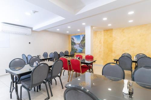 萨拉热窝Ornament Hotel and Apartments的一间会议室,配有桌子和红色椅子