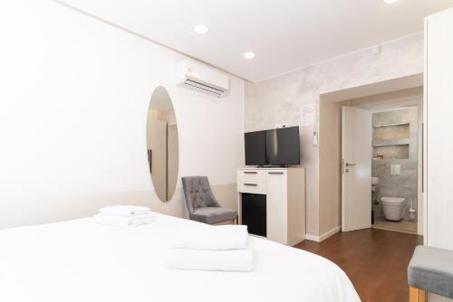 萨拉热窝Ornament Hotel and Apartments的白色的客房配有床和镜子