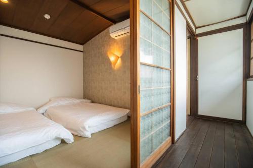 京都京·馨的一间卧室设有两张床和滑动玻璃门