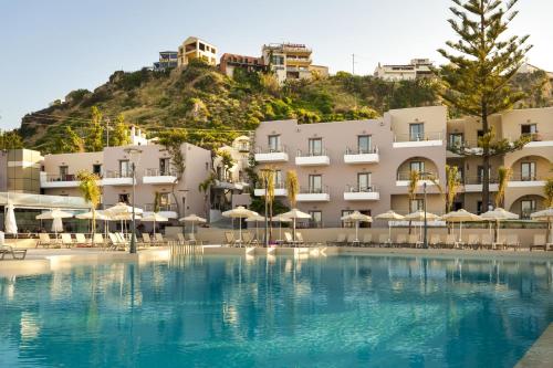 普拉塔尼亚斯波尔图普拉塔尼亚斯村公寓式酒店的酒店设有一个大型游泳池,配有遮阳伞