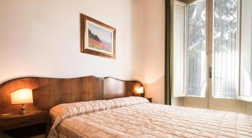 卡斯蒂利翁切洛Villa San Domenico的一间卧室设有一张大床和一个窗户。