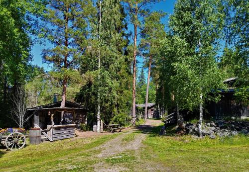 TuorilaNikolain tupa, vanha hirsitalo的小屋和谷仓前的土路