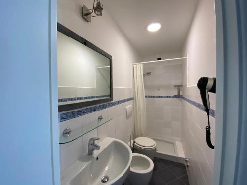 韦尔纳扎Pensione Sorriso的一间带水槽、卫生间和镜子的浴室