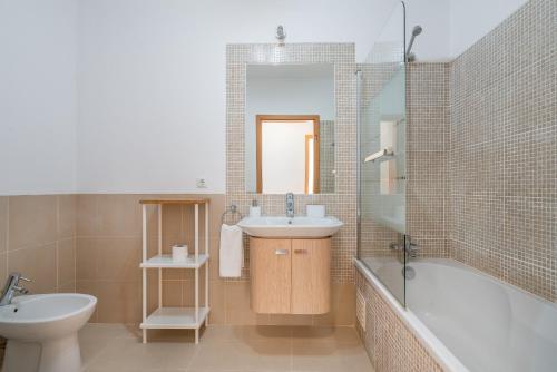 卡巴纳斯·德·塔维拉Delightful Cabanas 2 Bedroom apartment的一间带水槽、浴缸和卫生间的浴室