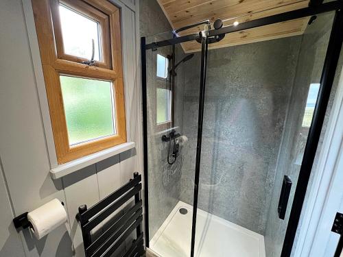 贝克韦尔Luxury Shepherd Hut in the Peak District的浴室里设有玻璃门淋浴
