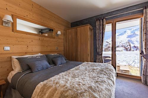 阿沃里亚兹Luxury Avoriaz Chalet with hot tub的一间卧室设有一张床和一个大窗户