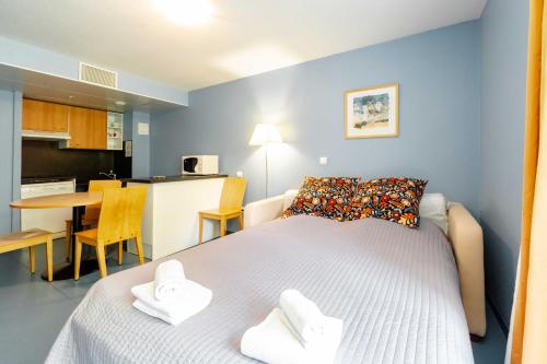 卢尔德玛利亚勒波平斯公寓式酒店的一间带白色床的卧室和一间厨房