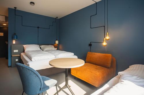 波鸿Nena Apartments Bochum City的一间设有四张床、一张桌子和一把椅子的房间