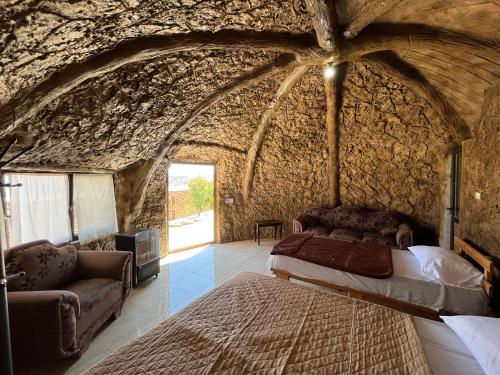 达纳Al-Nawatef ECO camp- Dana Nature Reserve的卧室配有一张石墙床