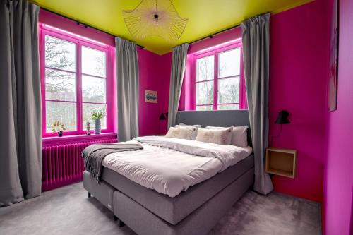 ÅmmebergHotel Montagne的一间卧室设有粉红色和黄色的墙壁和一张床