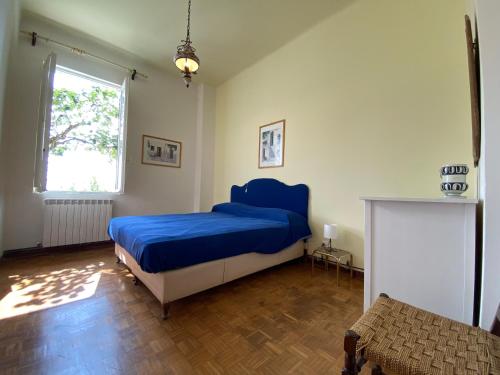 阿拉西奥Alassio prima collina spaziosa casa vista mare per 10 persone的一间卧室设有蓝色的床和窗户。