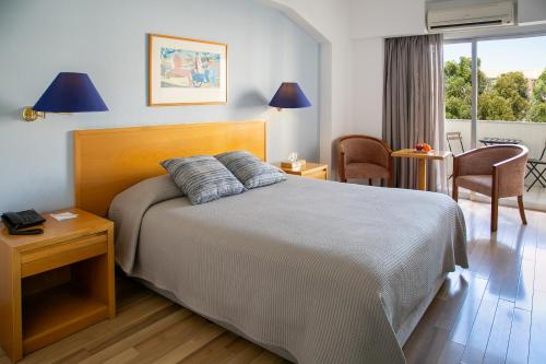 尼科西亚克娄帕特拉酒店的卧室配有一张床和一张桌子及椅子