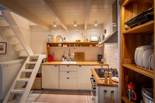 阿尔克马尔CityCottage Alkmaar的一间小厨房,配有白色的橱柜和梯子