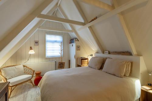 阿尔克马尔CityCottage Alkmaar的卧室配有白色的床和椅子