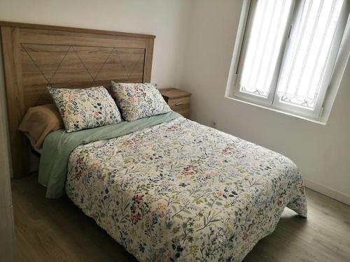 费罗尔Alojamiento céntrico con encanto的一间卧室配有一张带花卉床罩和枕头的床