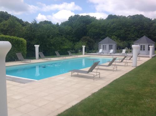 Loge-Fougereuse德拉高琼娜莉城堡旅馆的游泳池周围设有躺椅和椅子