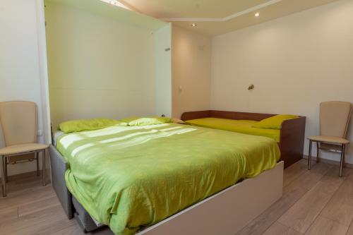 卢布尔雅那Studio Apartment Dominika的一间卧室配有两张带黄床单和两把椅子的床