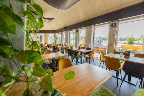 赫劳Oer't Hout的一间设有桌椅的餐厅,种植了植物