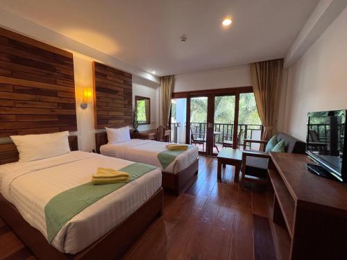 拉威海滩Phuket Meet Holiday Hotel 普吉岛相遇酒店的酒店客房设有两张床和电视。