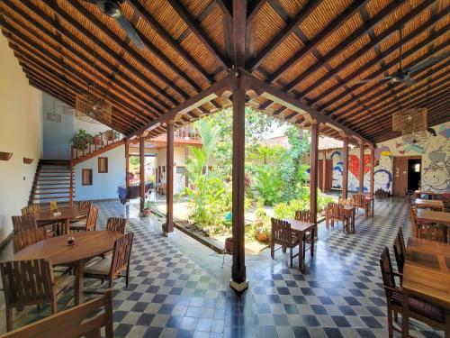 格拉纳达Hotel con Corazón的餐厅设有木桌和椅子,铺有 ⁇ 木地板
