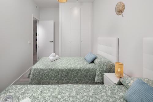 阿尔马亚特巴瑶Residencial Celere Playa Niza的白色客房内的两张床,配有两张sidx sidx sidx床