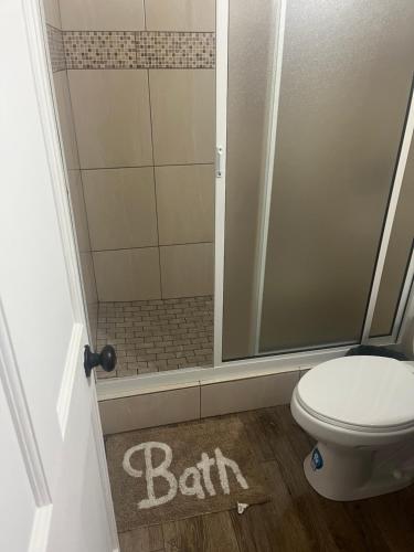 Paix Bouche2Bedroom Vacation Home的带淋浴的浴室以及位于地板上的带浴缸的卫生间。