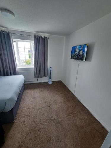 ThamesmeadImpeccable 2-Bed House in Thamesmead London的一间小卧室,配有床和窗户