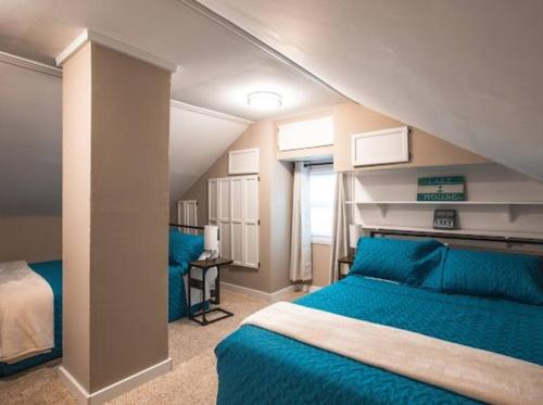 阿什塔比拉Wine Valley Bungalow的一间卧室设有两张蓝色的床和窗户