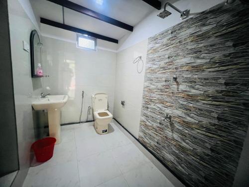 锡吉里亚Harini Villa的一间带卫生间和石墙的浴室