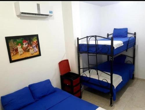 曼塔Hostal Playa Imperial Manta的客房设有两张双层床和一张沙发。