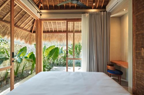 塞隆贝拉纳克Boni Beach Lombok Boutique Hotel的一间卧室设有一张床和一个大窗户