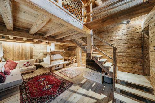 科尔蒂纳丹佩佐Luxury Cortina的客厅设有木墙和木楼梯。