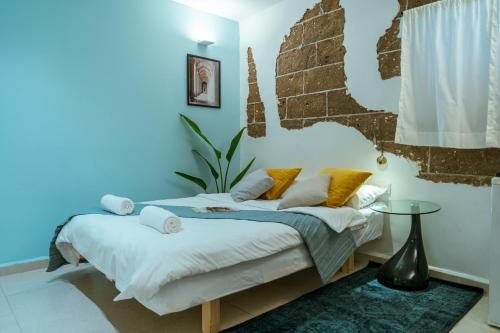 特拉维夫Jabitat- Jaffa Boutique TLV的一间卧室配有一张蓝色墙壁的床