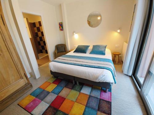 索姆河畔的圣瓦列里Le Relais des 4 Saisons - Chambres d'hôtes B&B en Baie de Somme的一间卧室配有一张色彩缤纷的地毯。