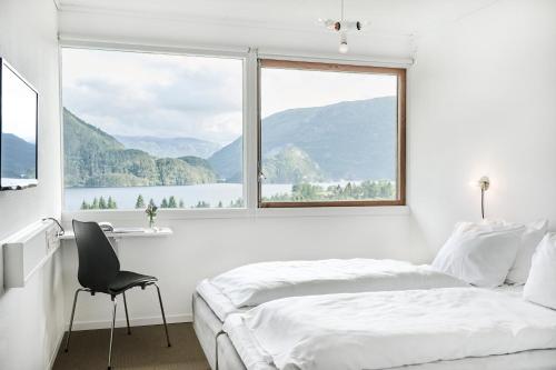 Nesflaten能源酒店的一间卧室设有一张床和一个大窗户
