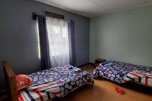 波特尔堡Harukooto Suites的一间卧室设有两张床和窗户。