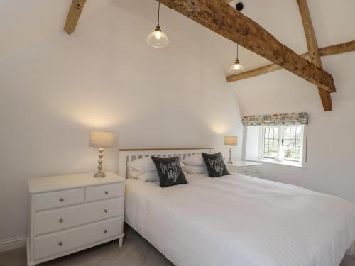 马姆斯伯里The Grooms Flat的卧室配有白色的床和窗户。