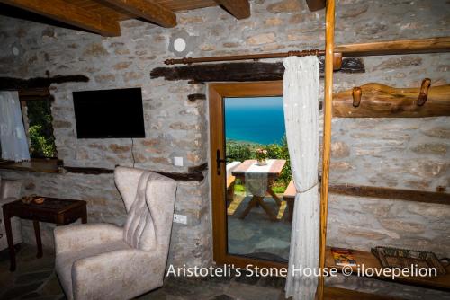 MakrirrákhiAristoteli's Stone House的客房享有桌子和窗户的景致。