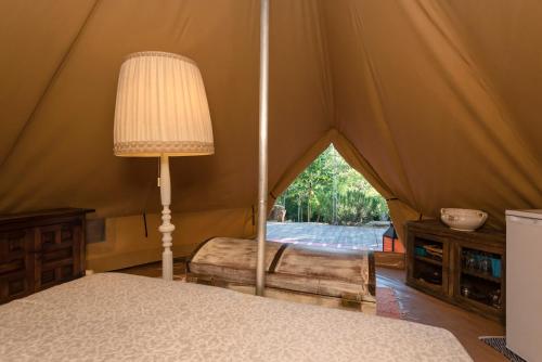 MonterotondoSerraiola Alta的帐篷内的卧室,配有一张床和一盏灯