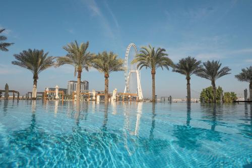 迪拜迪拜朱美拉海滩希尔顿逸林酒店的一座带摩天轮的游泳池