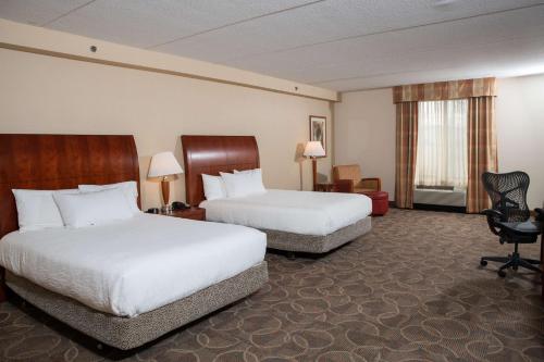 伊利伊利希尔顿花园酒店的酒店客房,配有两张床和椅子