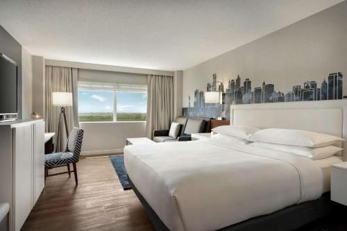 东拉瑟福德梅多兰兹希尔顿酒店的酒店客房设有一张白色大床和一张沙发。