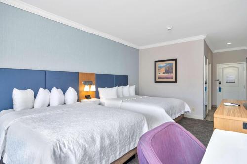 沃思堡沃斯堡-化石溪汉普顿酒店和套房的酒店客房配有两张床和一张书桌