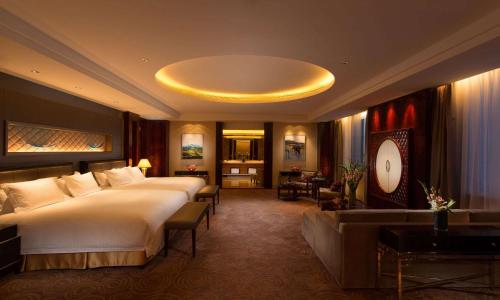 格尔木青海格尔木中浩希尔顿逸林酒店的酒店客房,设有两张床和一张沙发